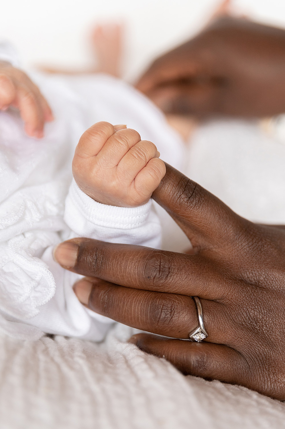 Baby hält den Finger der Mama mit seiner kleinen Hand ganz fest