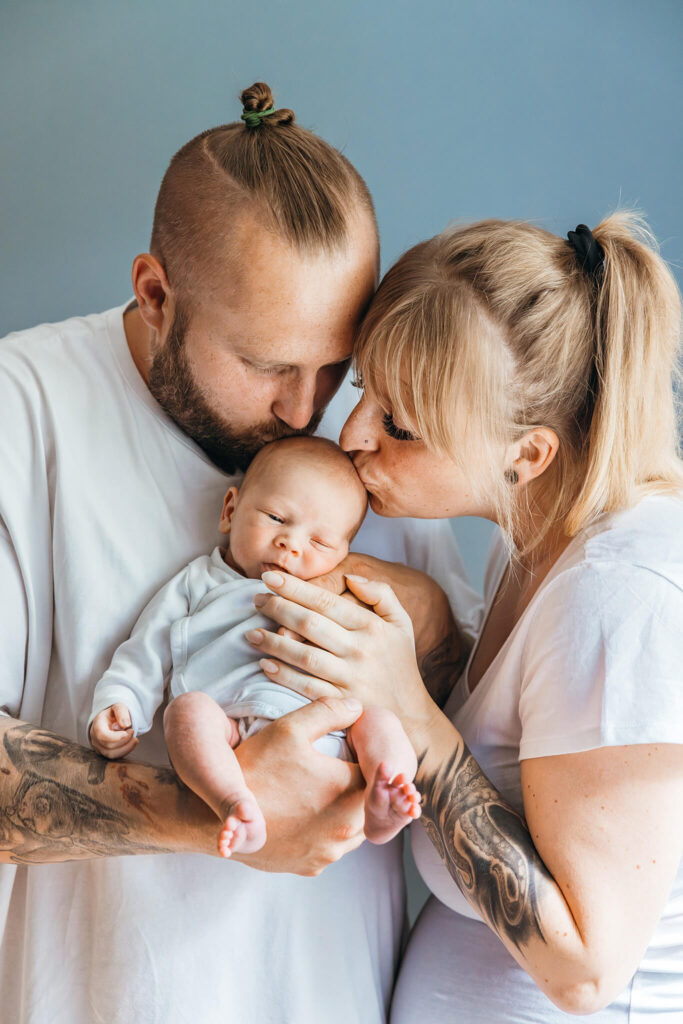 Neugeborenes Baby in Papas Armen, fotografiert in natürlichem Licht für natürliche Neugeborenenfotografie in Fürstenfeldbruck und Puchheim.